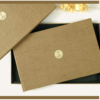 Luxury fabric-covered photo album with a minimalist gold emblem, displayed with a matching presentation box.